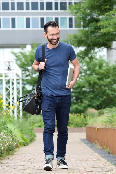 Happy mature man with handbag and laptop