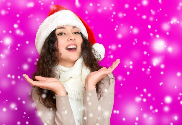 Girl in santa hat portrait on pink color background, christmas holiday concept, happy and emotions