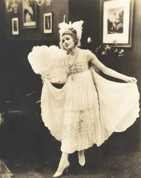 Woman in dress holding feather fan