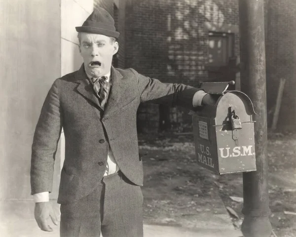 Man inserting hand in mailbox