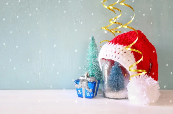 Cute knitted santa hat on mason jar with christmas tree