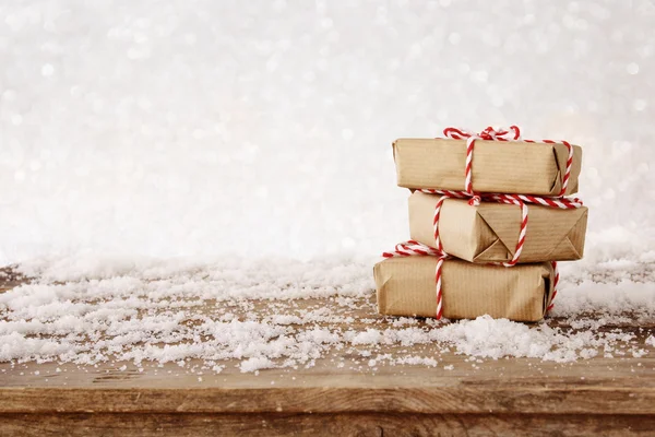 Handmade gift boxes over snowy wooden table