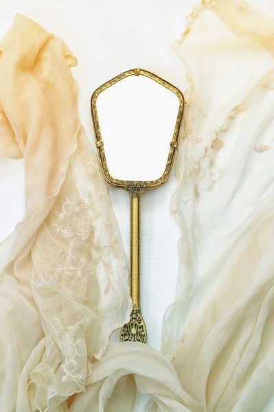 Top view image of vintage hand mirror and lace scarf