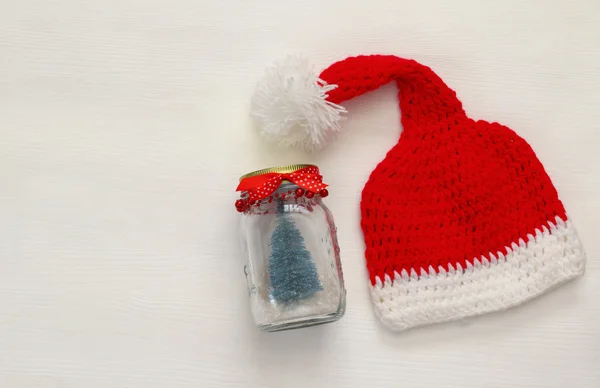 Cute knitted santa hat and mason jar with christmas tree