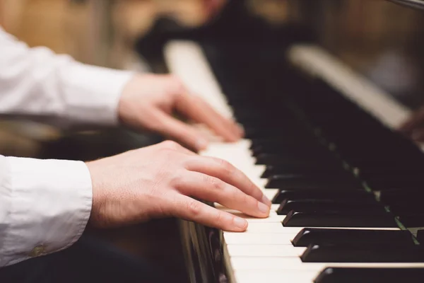 Close-up of a music performer\'s hand playing the piano