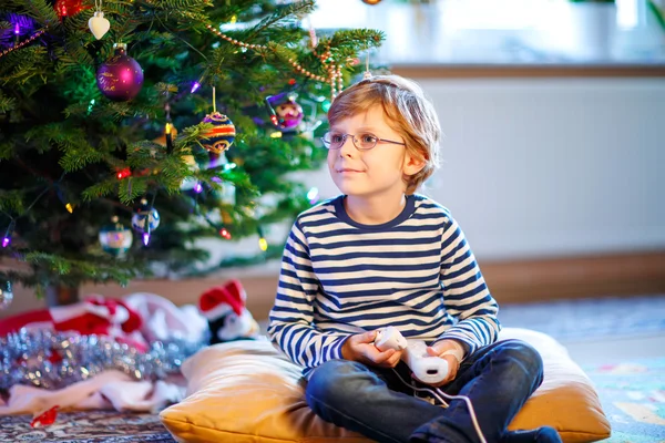 Little kid boy playing video game console on Christmas