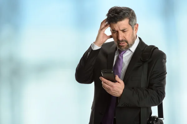 Worried Businessman Looking at Cellphone