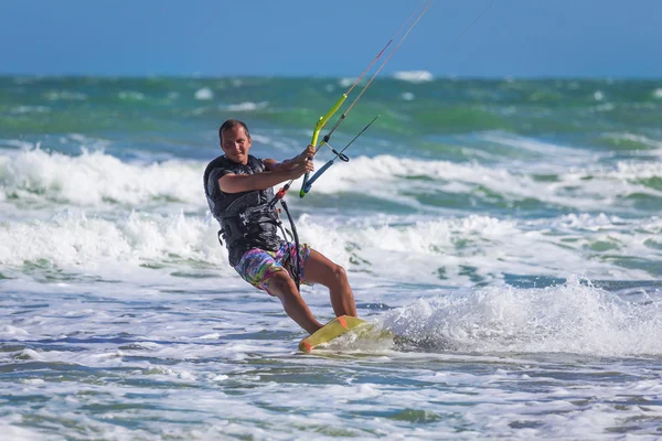 Athletic man jump on kite surf board sea waves