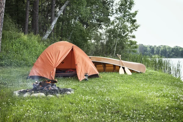 Tent, campfire and canoe on Minnesota lakeshore
