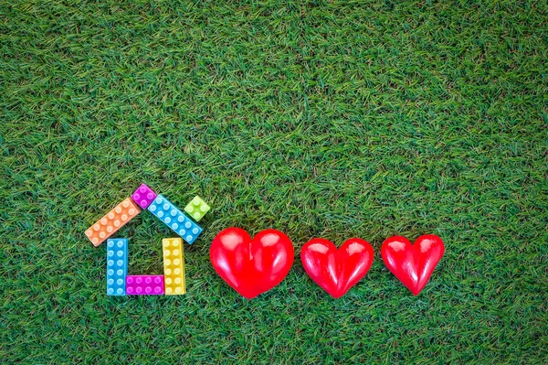 Home sweet home concept with home model and three red hearts on