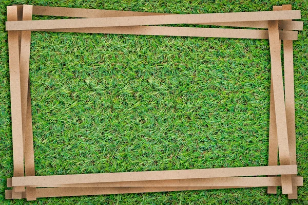 Frame of recycle paper cut with free copy space on green grass