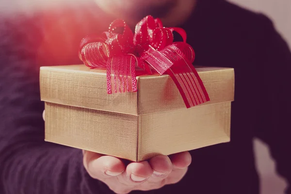 Gift giving,man hand holding a gift box in a gesture of giving.b
