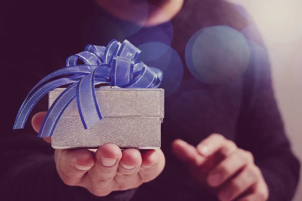 Gift giving,man hand holding a gift box in a gesture of giving.b