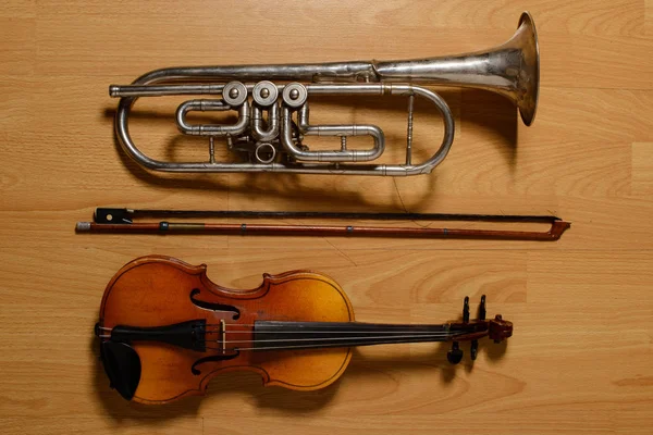 Broken trumpet and violin on the wooden floor