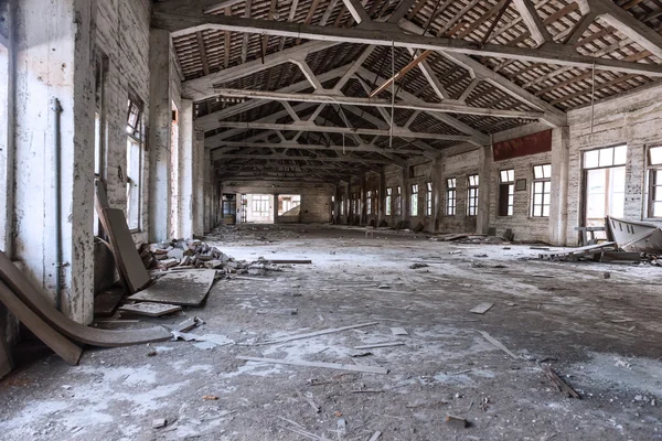 Empty industrial loft in an architectural background with bare cement walls, floors and pillars supporting a mezzanine