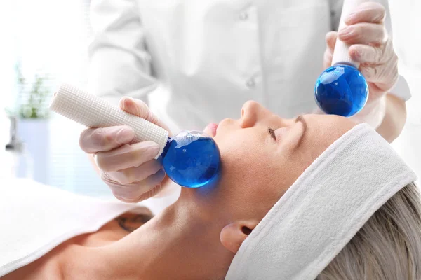 Massage the face with glass balls.