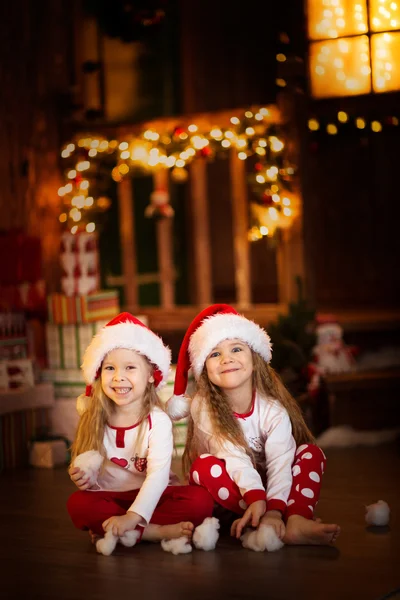 Girls sister friends hugging sitting at  Christmas tree, concept