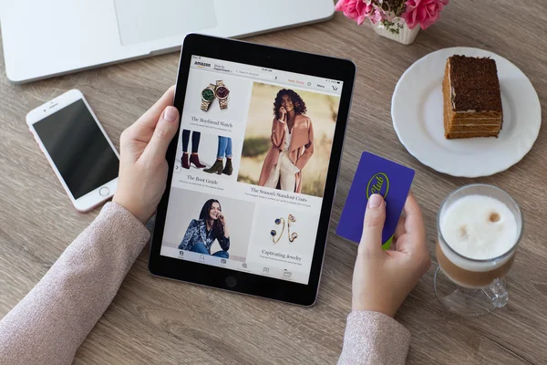 Woman holding iPad Pro with Internet shopping service Amazon