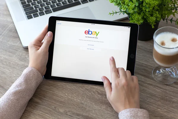 Woman holding iPad Pro with Internet shopping service eBay