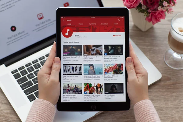 Woman holding iPad Pro Space Gray with website YouTube