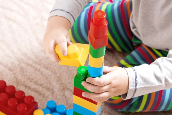 Playing little boy with colored cubes