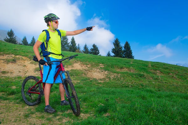 A young man riding a mountain bike outdoor covers the path