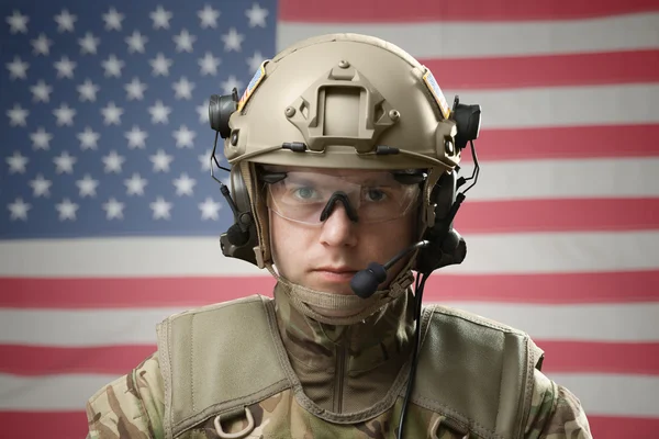 Young military man wearing helmet with USA flag on background