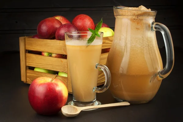 Fresh pressed apple juice unfiltered. Apple juice and apples on wooden table. A healthy juice for athletes. Autumn apple harvest.