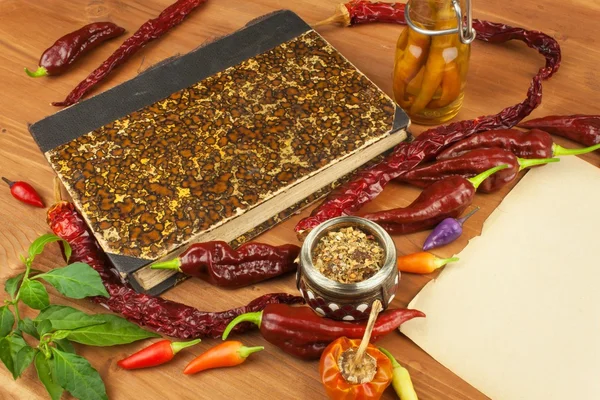 Cookbook and chillies. Recipe for spicy food. Mexican cuisine. Food preparation according to the old recipe book. Grandma\'s recipe book. Old recipes for cooking.