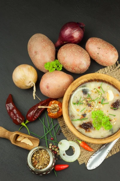 Homemade potato soup with mushrooms. Bowl with potato soup on wooden table. Food preparation.