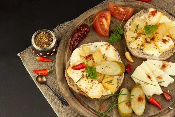 Two kinds of cheese on bread. Healthy breakfast on the kitchen table. Bread with cheese cherry tomato and chilli.