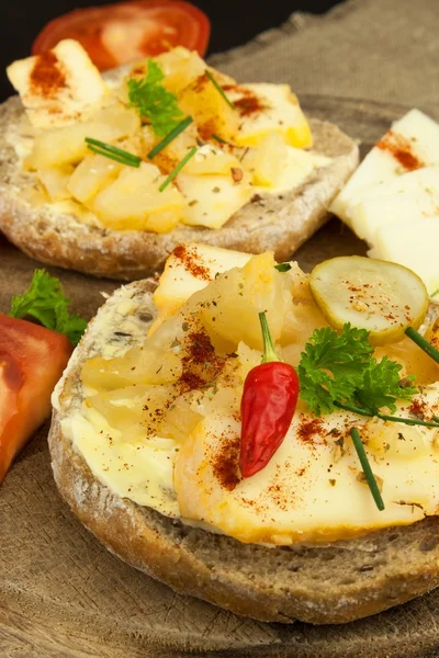 Two kinds of cheese on bread. Healthy breakfast on the kitchen table. Bread with cheese cherry tomato and chilli.