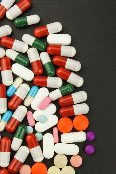 Detailed view of multicolored pills. Pharmaceutical industry. Colorful pills on black background