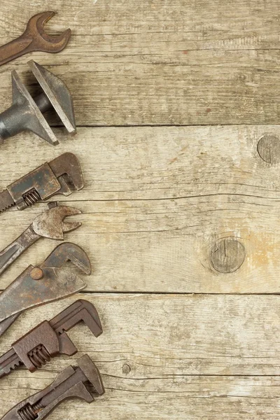 Dirty set of hand tools on a wooden background. Old rusty tools. Equipment for locksmith and metalworking shop. Sales tools for assembly workers. Old shop.