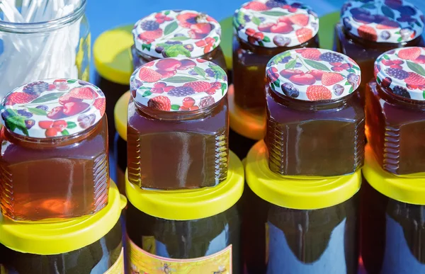 Different varieties of honey in banks, offered for sale at the f