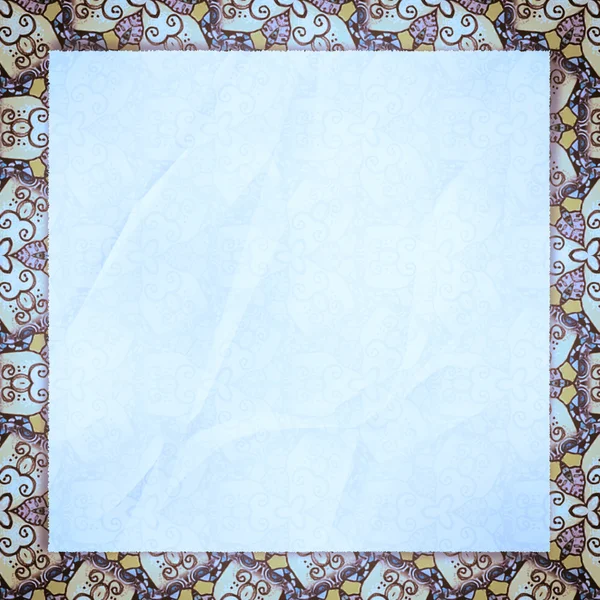 The crumpled form lies on azure wall-paper, with an abstract spi