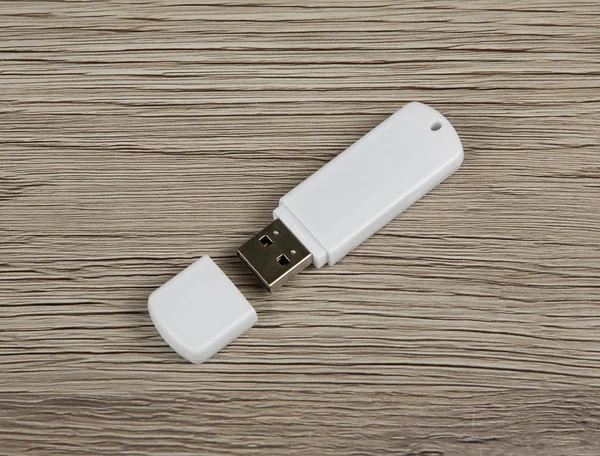 White usb flash drive on wooden background.