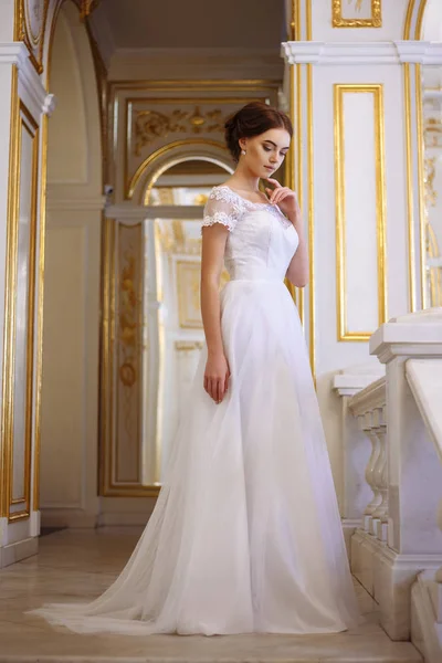 Beautiful young woman bride in luxury wedding dress in interior