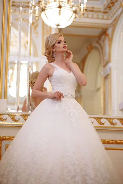 Beautiful young woman bride in luxury wedding dress in interior