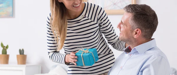 Woman giving the present to her disabled husband