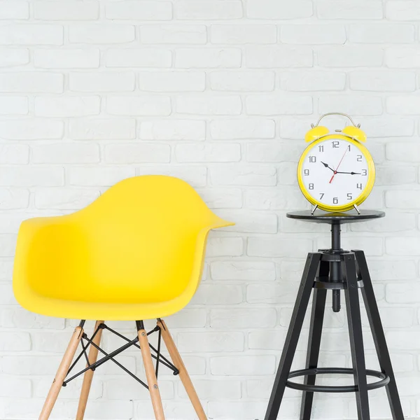 Yellow chair and alarm clock