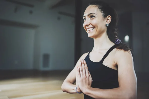 Portrait of gorgeous young woman practicing yoga indoor. Beautiful girl practice meditation asana in class.Calmness and relax, female happiness.Horizontal, blurred background.