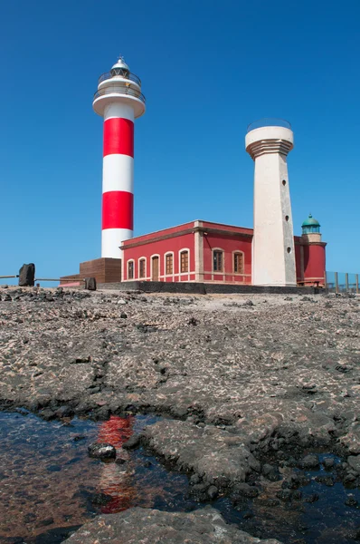 Fuerteventura: black rocks with El Toston Lighthouse at Punta de la Ballena, Whale Point in english