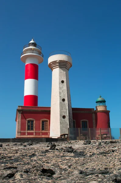 Fuerteventura: black rocks with El Toston Lighthouse at Punta de la Ballena, Whale Point in english