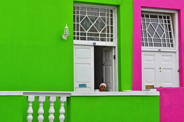 South Africa: a muslim woman at the door of a green house in Bo-Kaap, the muslim quarter of Cape Town