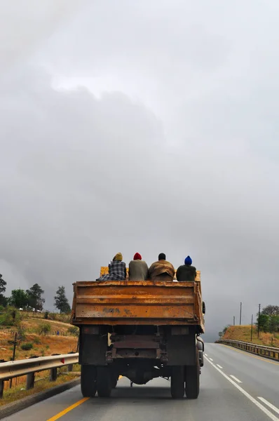 South Africa: four men on a truck in a cloudy day on a street in the land of the Zulus
