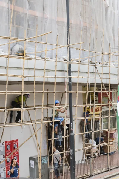 Hong Kong - October 17, 2016: Construction workers build a wooden framework in downtown Hong Kong