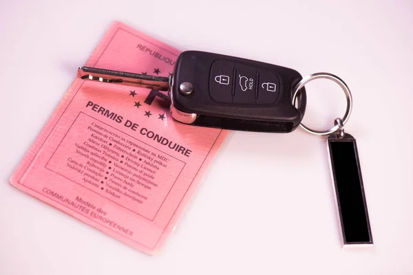 Car keys and drivers license on white background