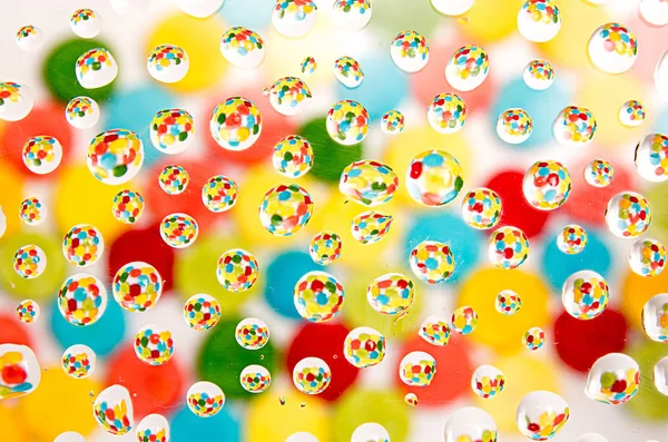 Multi-colored background with reflection in water drops