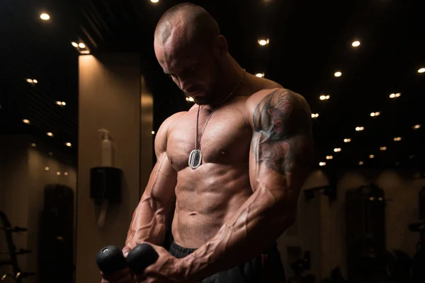 Muscular Man Exercising Biceps On Cable Machine